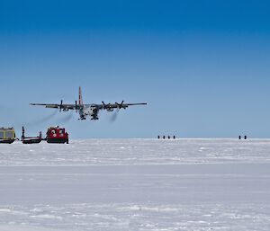 Hercules about to land on snowy terrain and a red Hagg in the foreground