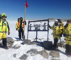 Survival training crew in a rocky and snowy terrain, standing next to the Shirley Island sign
