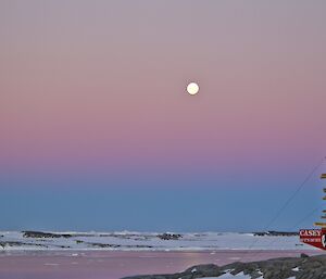 Newcombe bay with a pink and purple sky with a orange moon in the background, Casey station sign on the foreground