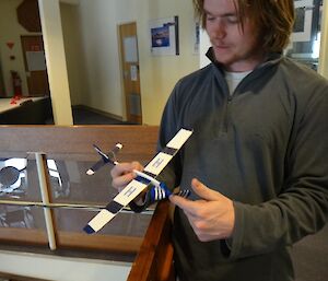 Ben holding a model airplane, dreaming of a busy summer flying program.
