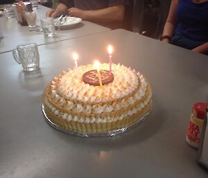 A lemon meringue pie with happy birthday written on top in cream