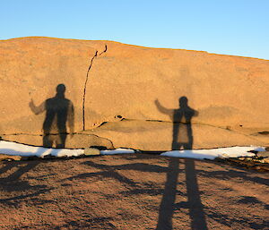Two long shadows projected against the rocks.