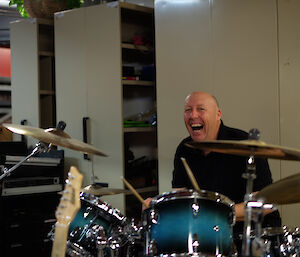 An expeditioner playing drums during band rehearsal