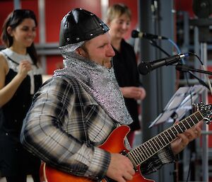 An expeditioner playing guitar during band rehearsal