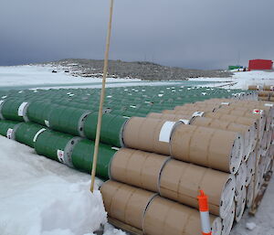 Sorting of fuel drums by colour — brown drums stacked beside green drums