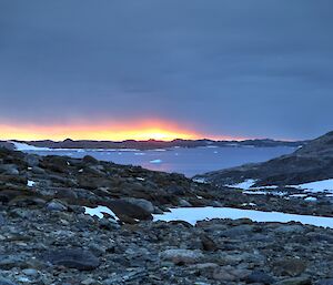 Last rays peek from under a thick blanket of cloud