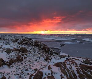 View of the sun sinking below the horizon from Reeve’s Hill at Casey station