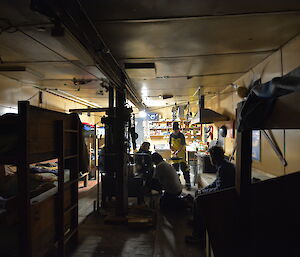 Expeditioners prepare food for dinner in a field hut