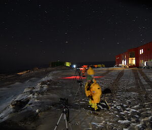 A group of expeditioners outside Casey station photographing Auroras