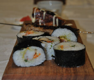 A close up of sushi with expeditioners in the background