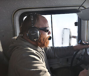An expeditioner driving an Hägglunds in Antarctica