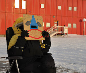 Alison Dean with safety mask sitting in a deck chair to observe the partial solar eclipse at Caey 29 April 2014.