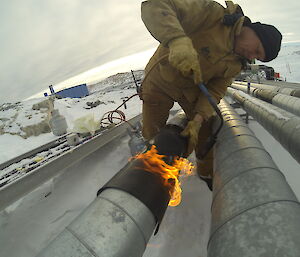 Plumber Ian Coleman applying heat shrink to a weld join