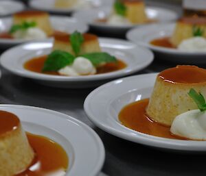 Crème caramel on plates with sauce