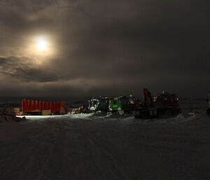 Vehicles photographed at night under a full moon