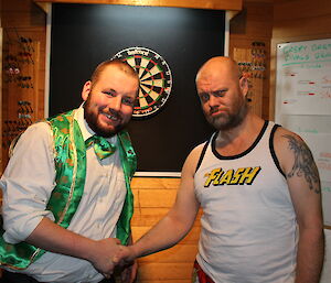 Scott Clifford shakes hands with Steve Black following a darts match at Casey