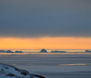 Icebergs silhouetted against the setting sun at Casey