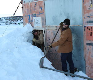 Digging snow away from the doorway at the Wilkes Hilton hut on the Clark Peninsula