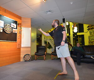 An expeditioner playing darts, at Casey station, Antarctica