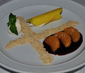 Deconstructed cheesecake with the crust separate from the cake, used as a cross decoration on the plate — a decorative dish