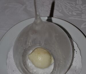 A large, teardrop shaped, thin ice ‘igloo’ containing lemon sherbet sorbet