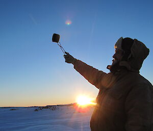 An expeditioner takes the air sample