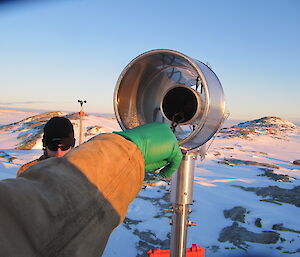 An expeditioner carefully places the new filter inside the air sampler