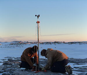 Expeditioners changing over the wind data logger