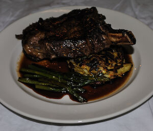 A large cooked beef steak served with vegetable and gravy