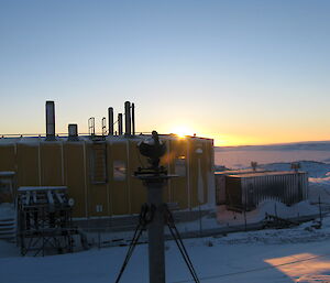 Sun breaching horizon in background of the Meteorological sunshine recorder at Casey station.