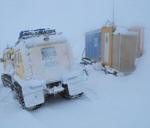 Brownings hut and Hägglunds vehicle in a snowstorm, south of Casey station