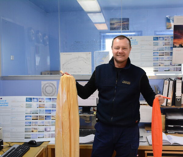 An expeditioner in the operations building at Casey, receiving an meteorological prize pack.