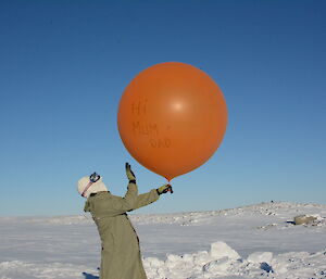 An expeditioner prepares to launch a weather balloon at Casey station, Antarctica