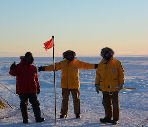Expeditioners plant a flag at the exact latitude of the Antarctic circle