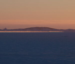 Steam rising above the almost frozen ocean at sunset