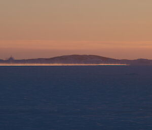 Steam rising above the almost frozen ocean at sunset