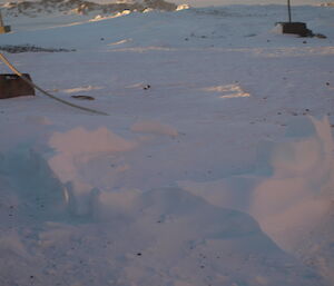 An attempted igloo is reduced to a few small ridges in the snow due to wind erosion