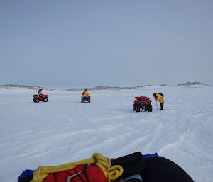 Quad bikes parked on the sea ice whilst the thickness of the ice is drilled and tested by an expeditioner