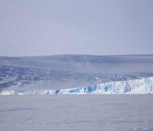 The view looking up the coastline from the seaice, with features of crevasses and cliffs at the sea ice edge