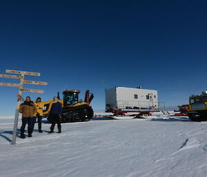 Four of the trip members with vehicles in front of the Lanyon Junction sign on a beautiful clear day