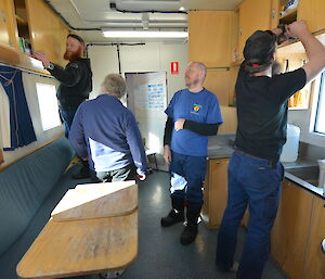 Expeditioners searching through the traverse van cupboards for the Tea