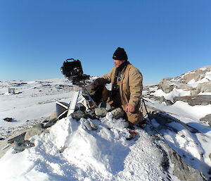 An expeditioner servicing the camera which is trained on an Adélie penguin breeding colony at Whitney Point