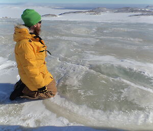 Dan kneeling next to an ice-dome near Robbos hut