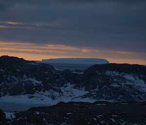 A large iceberg visible from Browning Peninsula sillouetted in the evening sun