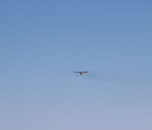 A C-130 Hercules in the distance above a stark landscape, nearing approach path to the Casey skiway