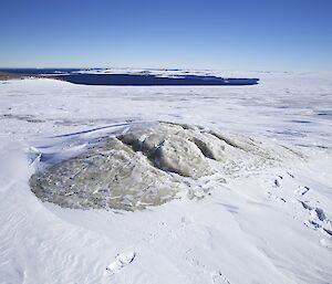 A raised dome with a fissure along the top marking an exit point for subglacial water