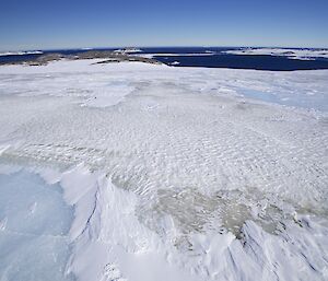Contrast between aqua blue ice sheet and frozen sediment laden outburst flow