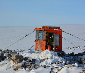 An expeditioner shovels accumulated snow out of the toilet building near Jack’s hut.