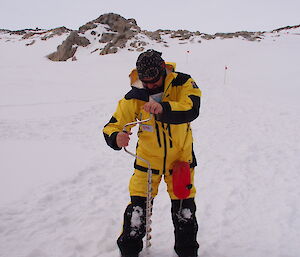 An expeditioner drills the sea ice to check for the thickness