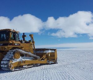 A bulldozer pushes snow to clear the edge of the runway at Wilkins